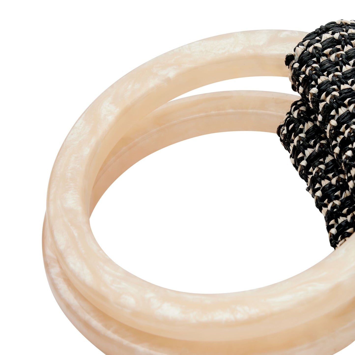 Close-up of beige resin rings with a black and beige raffia handle on a white background