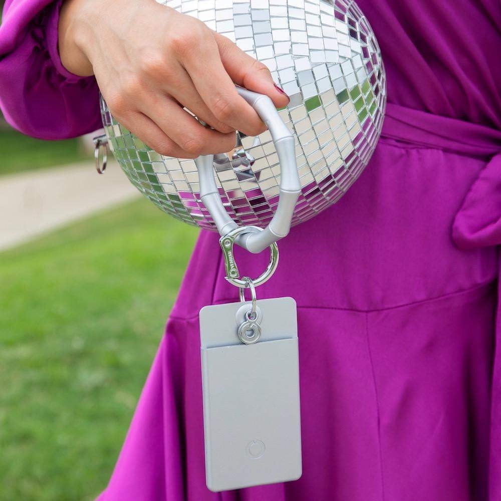 Sleek silver ID case for secure cards worn as a wristlet.