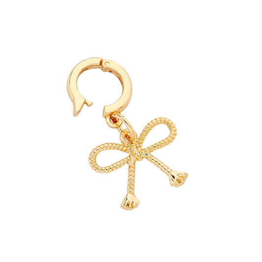 A gold-colored bow-shaped charm with a huggie-style closure.