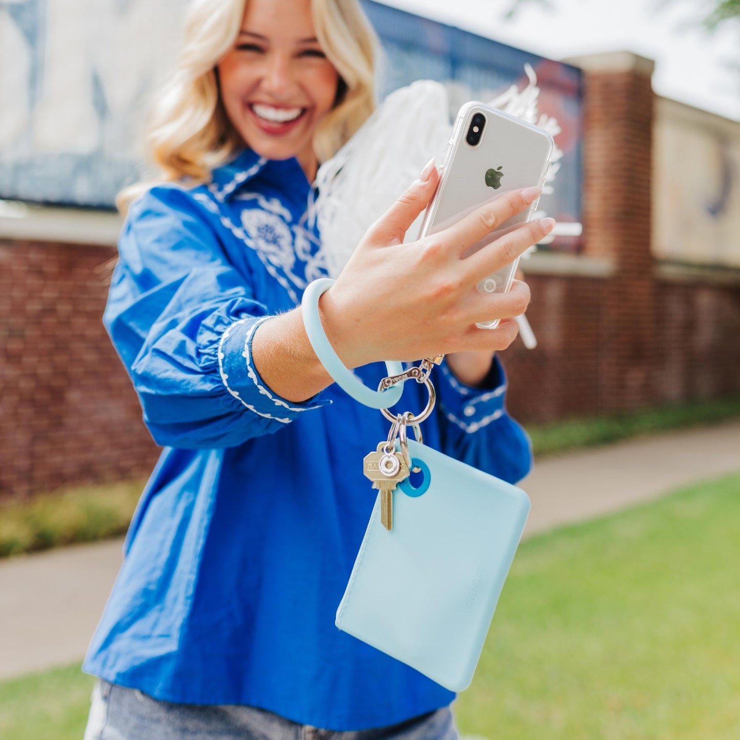 Stylish light blue silicone mini pouch for everyday shown with key ring bracelet.