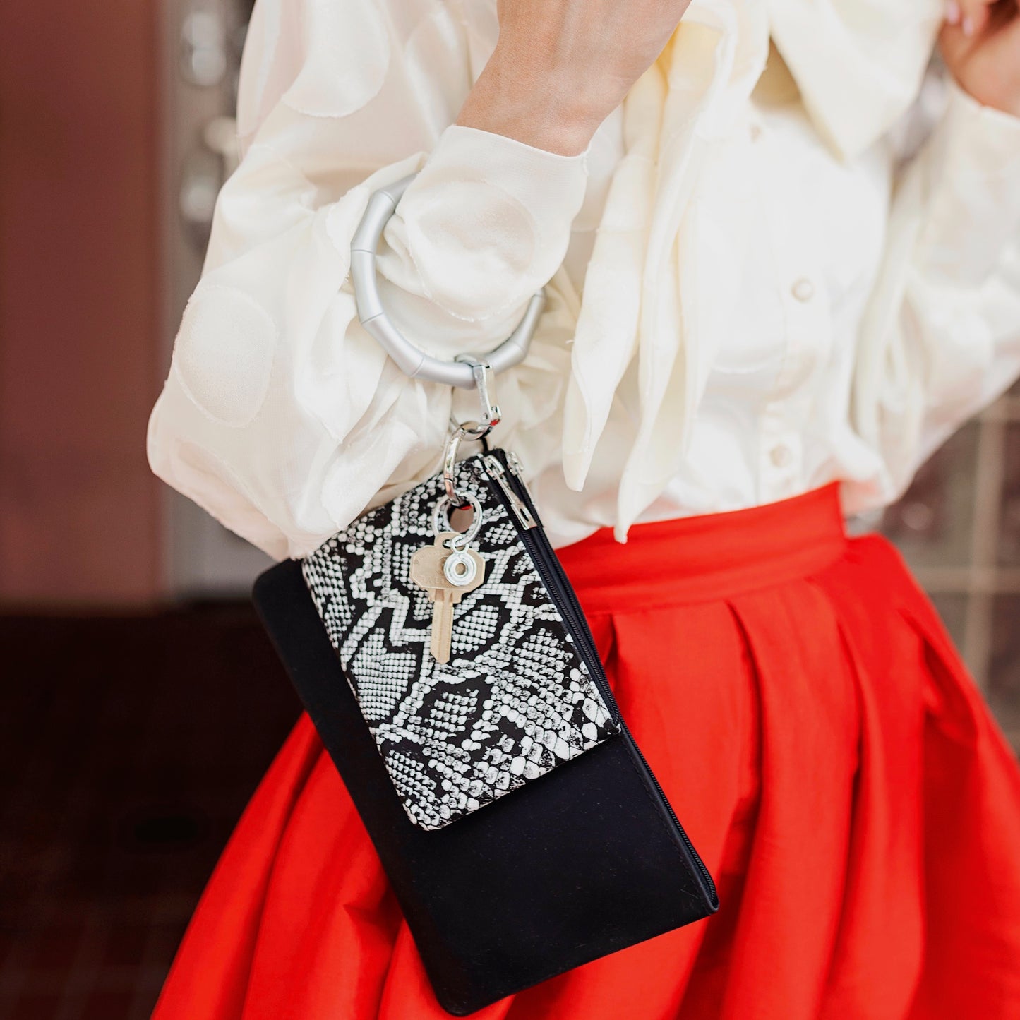 Black and white snakeskin print silicone mini pouch layered with a large silicone back in black pouch attached to bamboo solid quicksilver big O key ring mini pouch with silver hardware