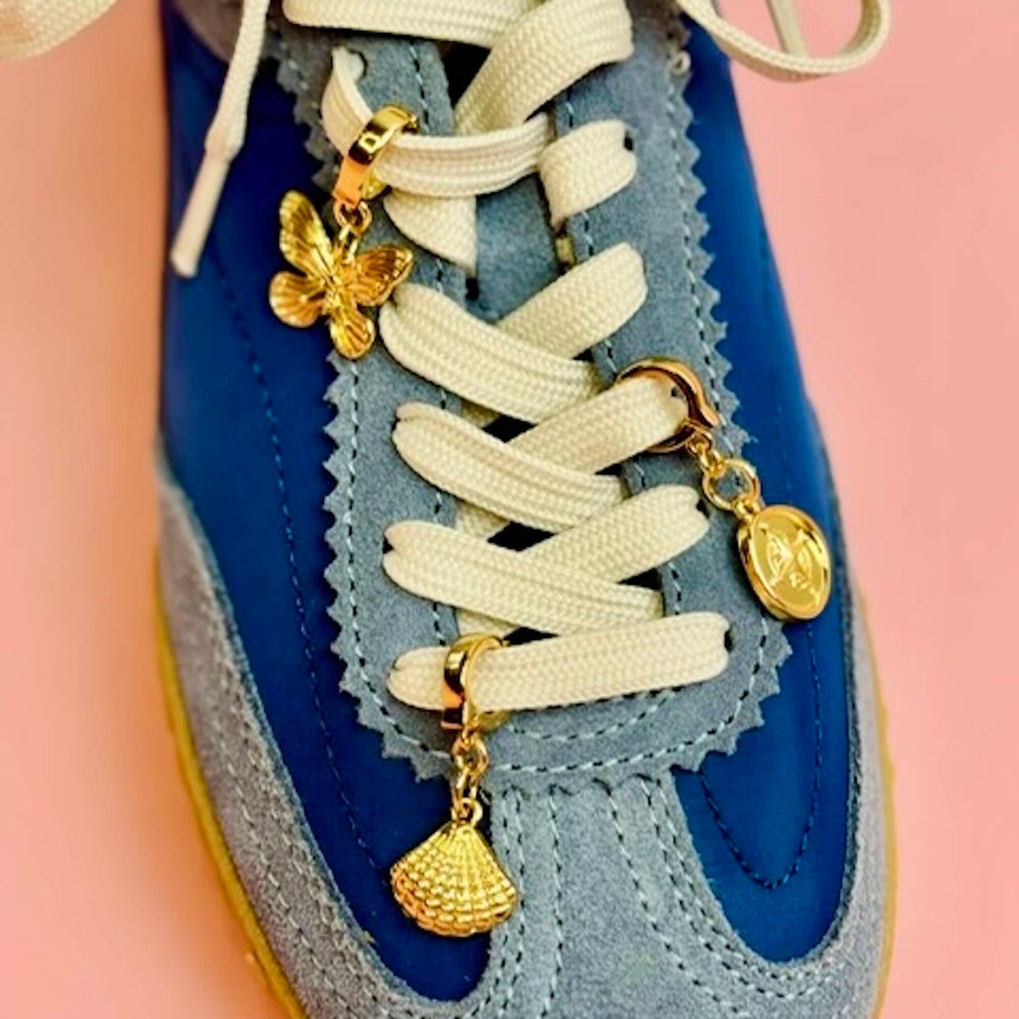 Gold butterfly, shell and compass shoe charm on blue tennis shoes