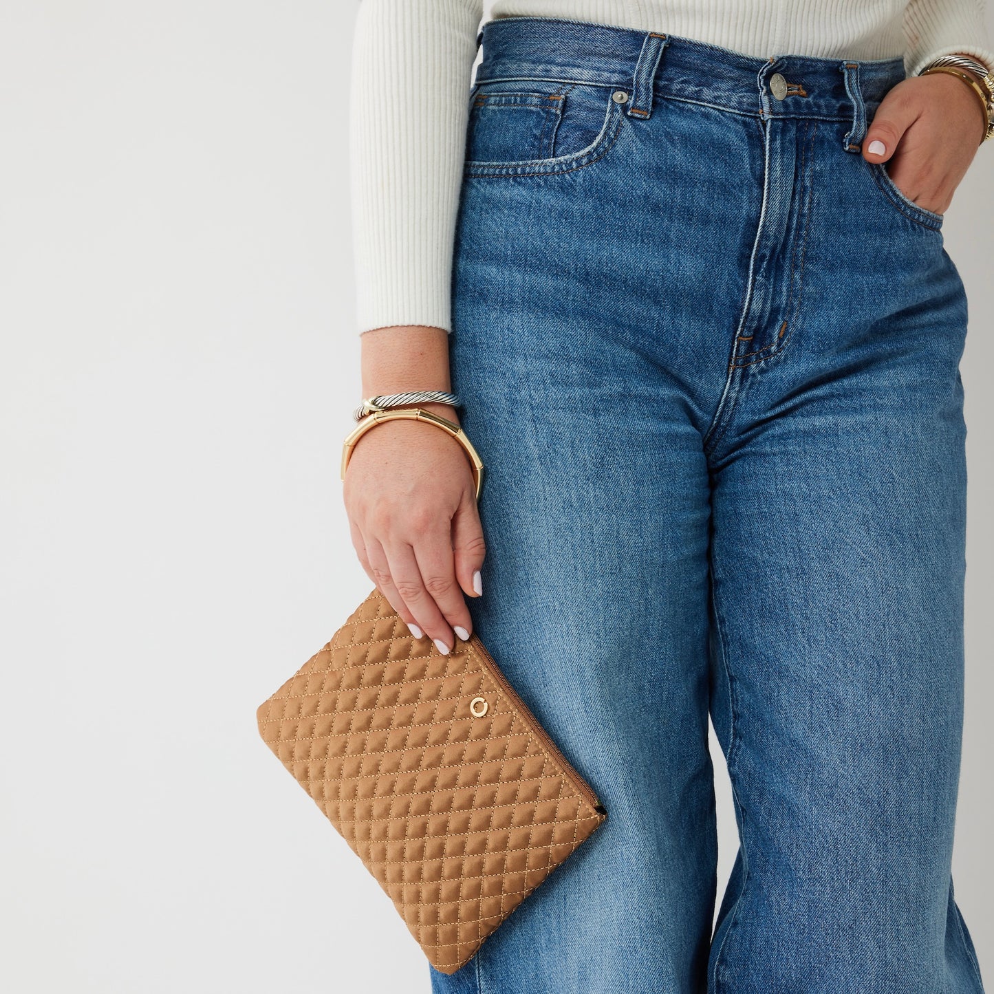 A versatile caramel clutch bag with bracelet handle