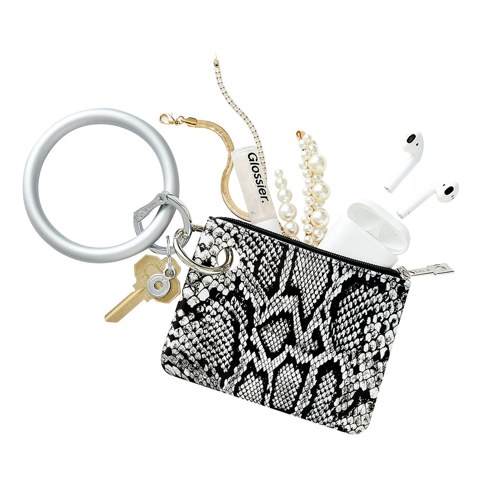 Oventure black and white snakeskin mini pouch print with silicone big o key ring in solid quicksilver. Jewelry, air pods and lip gloss coming out of the top of the mini pouch