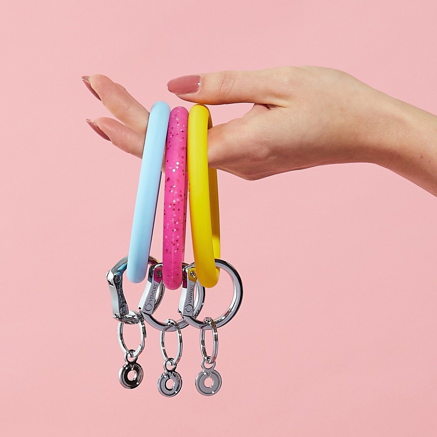 Stack of 3 smooth silicone Big O Key Rings in Sweet Carolina Blue, Tickled Pink Confetti and Yes Yellow