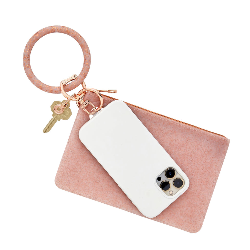 The three in one set includes a big o key ring in rose gold confetti, a large silicone pouch in rose gold confetti and a hook me up phone connector with rose gold hardware.