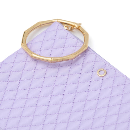In The Cabana Quilted Bracelet Pouch  with gold bamboo bracelet attached.