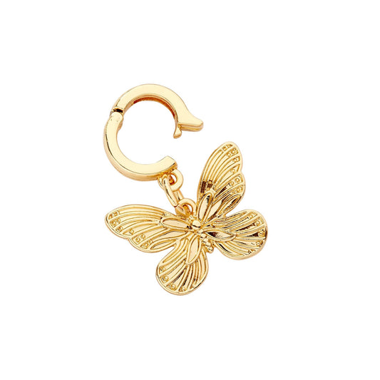 A gold-colored butterfly charm with a huggie closure designed to clip onto accessories like bracelets and phone cases.