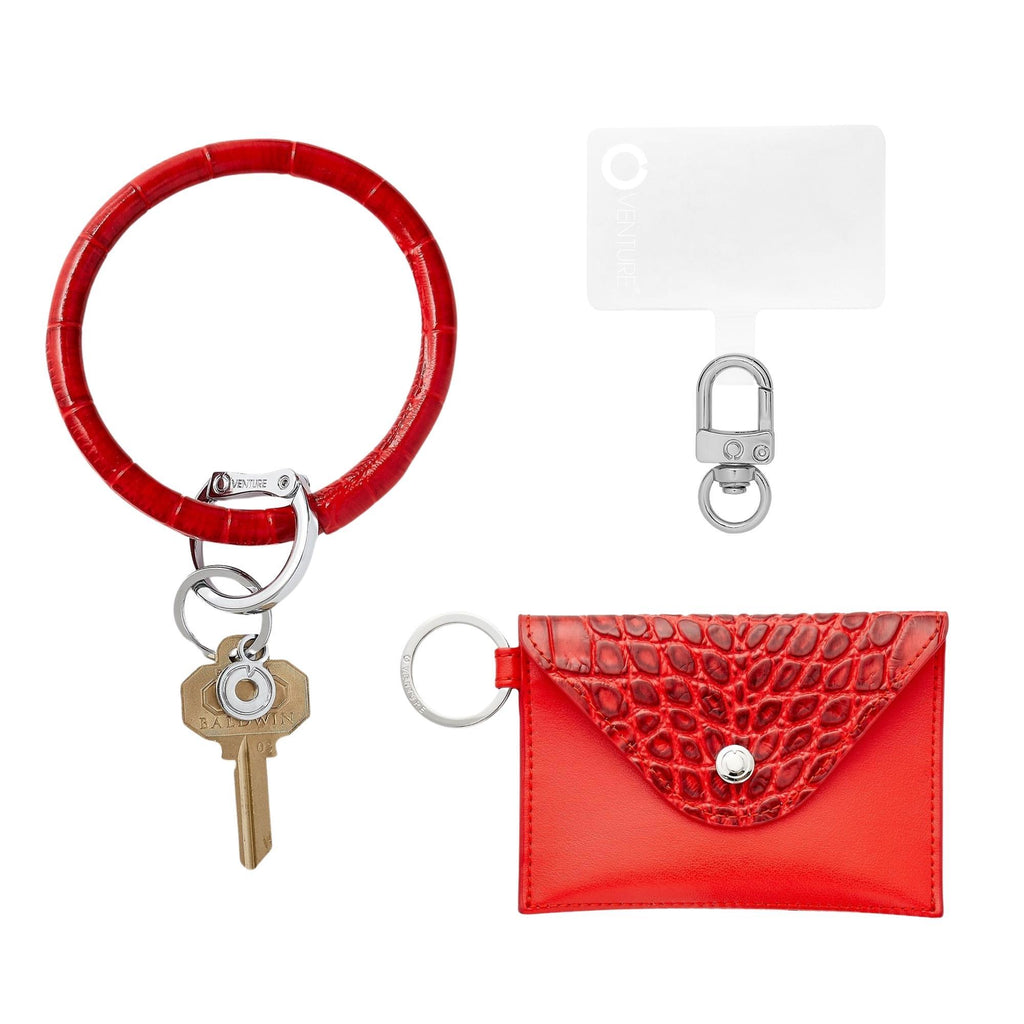 3-in-1 Cherry On Top Leather Mini Envelope Set - Oventure. The Set includes a Big O Key Ring in red croc embossed leather, a hook me up phone connector, and a mini envelope wallet in red croc embossed leather