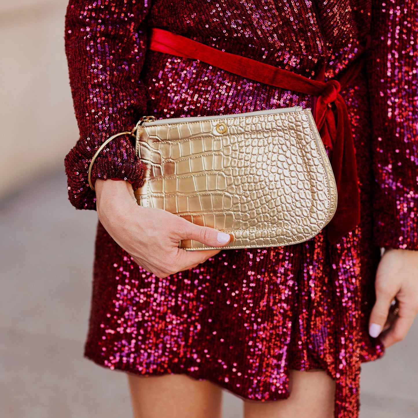 Solid Gold Rush Croc Embossed Big O Bracelet Bag paired with a sequin dress.