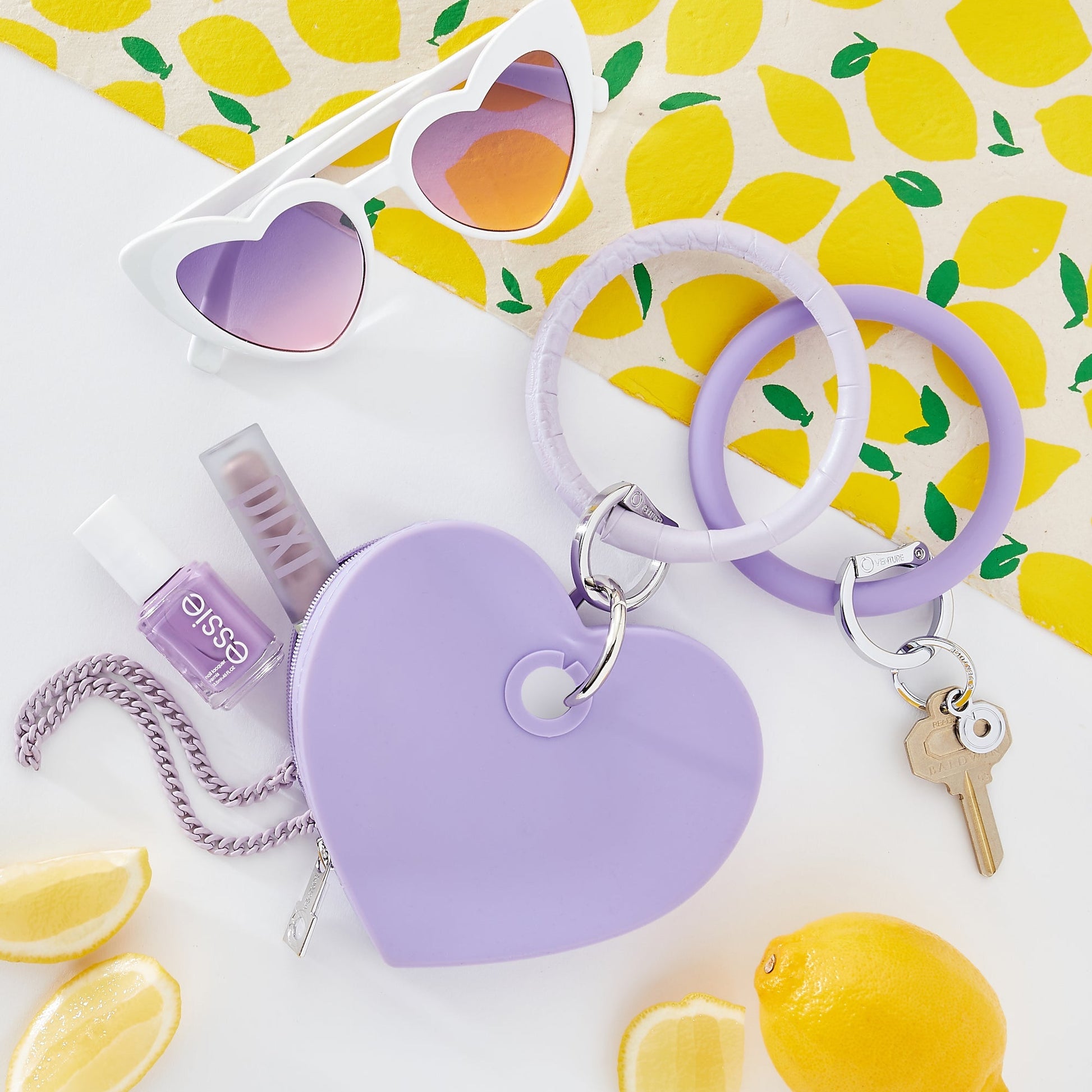 In The Cabana - Silicone Heart Shape Pouch with Big O Key Ring attached shown with nail accessories and sunglasses
