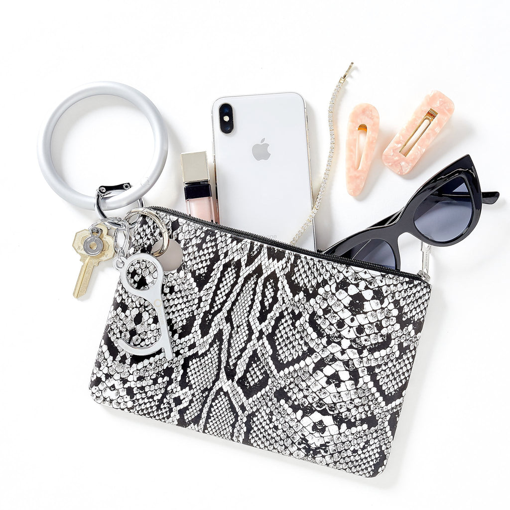 Oventure Large Silicone Pouch with black and white snakeskin print. and silver hardware. Laying flat with phone and accessories coming out of the top 