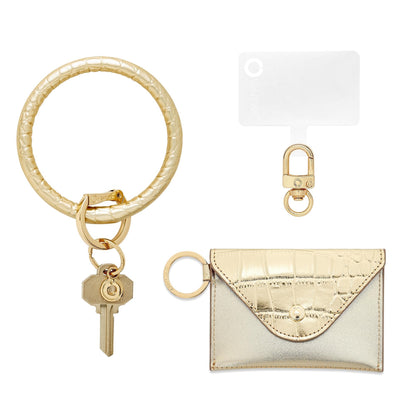 3-in-1 Gold Rush Leather Mini Envelope Set - Oventure. This includes a Big O Key ring in gold leather, a mini wallet envelope in gold leather and a phone connector with gold hardware
