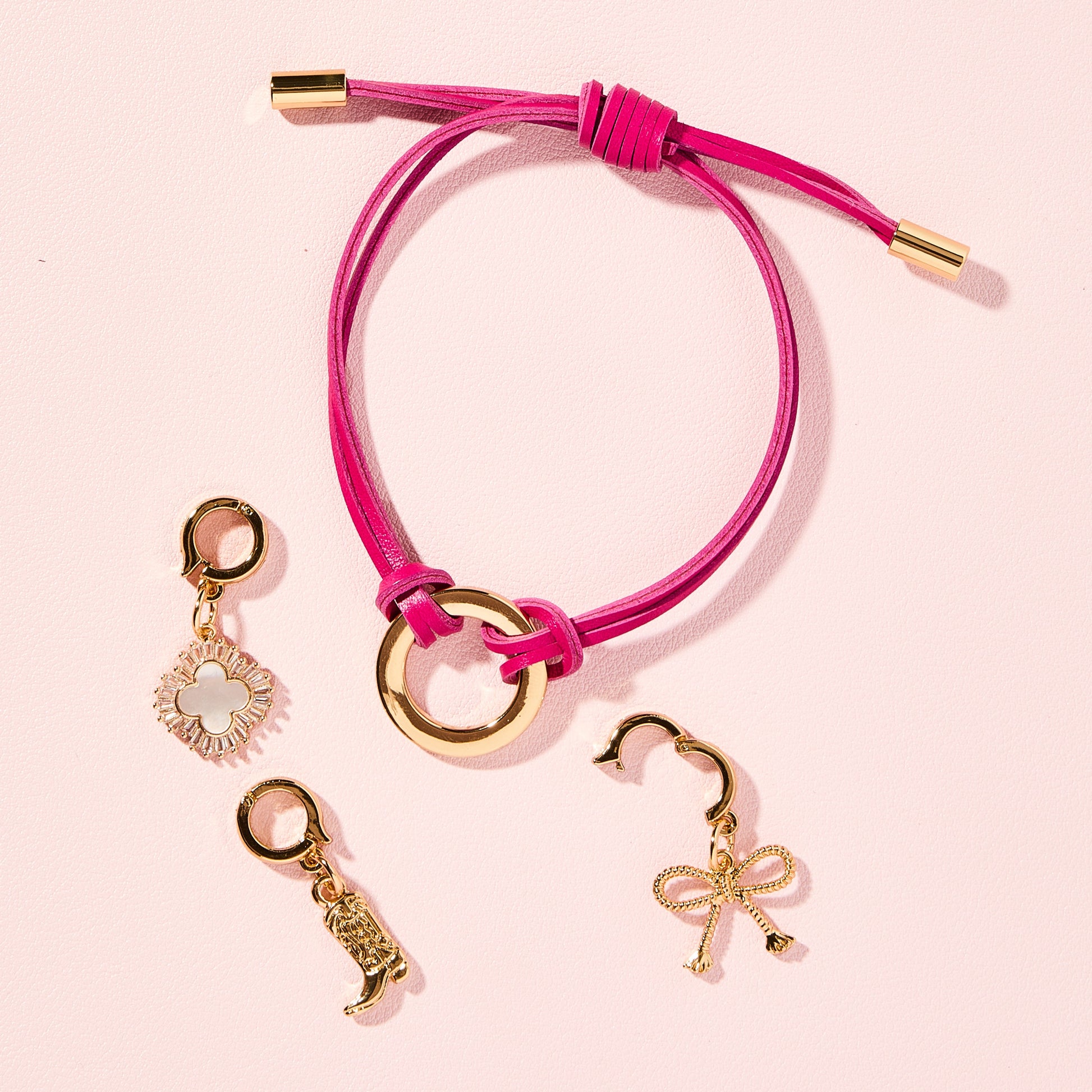 Pink Leather adjustable cord bracelet shown with trendy gold detachable charms 