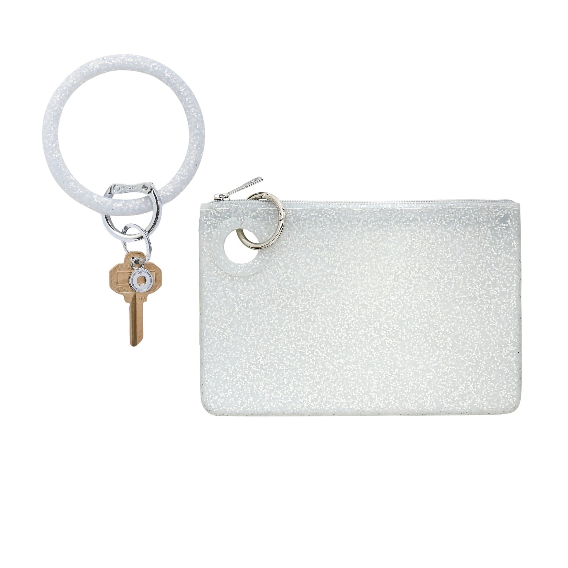 White glitter silicone Big O® Key Ring with silver clasp and house key, paired with a matching large silicone pouch wristlet in white glitter finish, shown on a white background.
