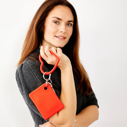 Stylish red silicone mini pouch shown as wallet wristlet.