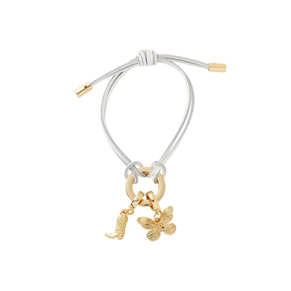 Bracelet with gold charms including a butterfly and a boot on a white background