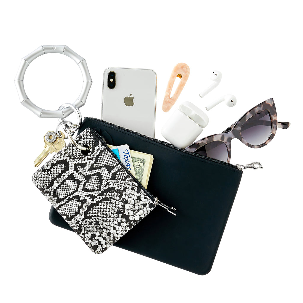 Back in Black - Large Silicone Pouch - Oventure attached to Big O Key Ring in silver bamboo silicone. Pouch holds iphone, air pods and sunglasses. Mini pouch in tuxedo snakeskin printed silicone holds cash and cards