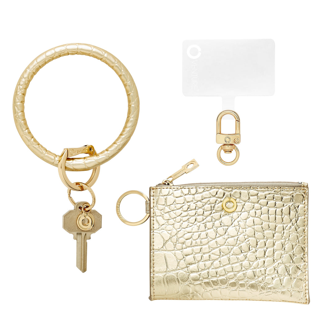 Oventure three in one set in solid gold rush croc embossed leather includes a keyring and ossential wallet.  It also includes phone connector with gold hardware.